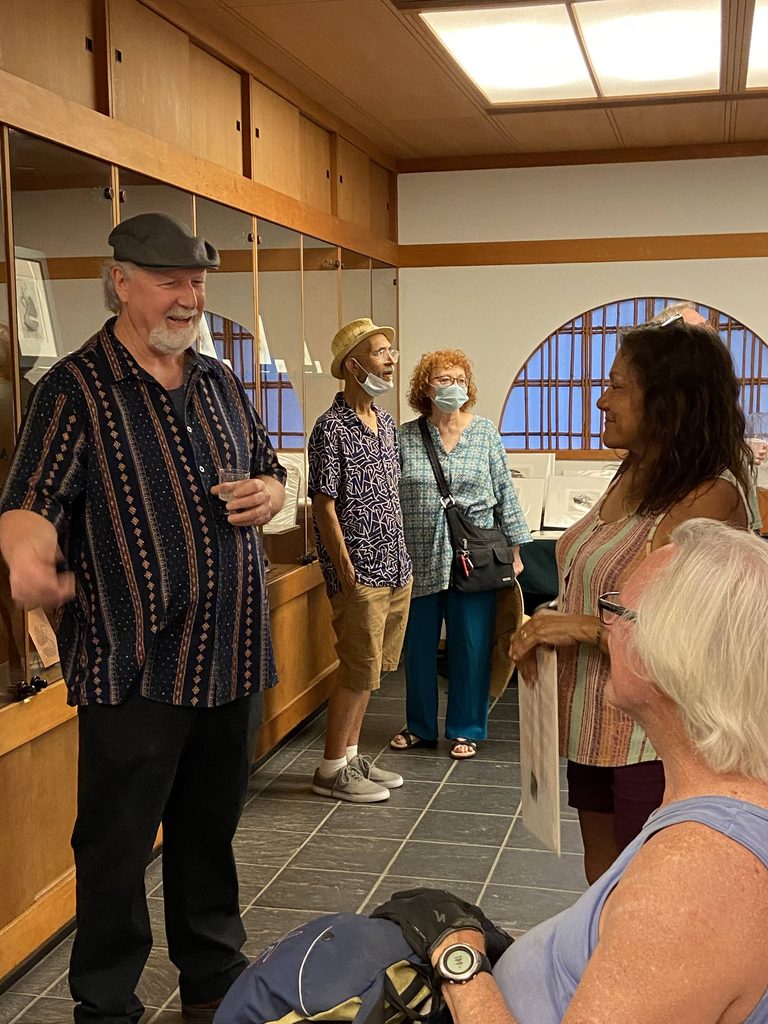 Artist Ron Reekers smiling and talking with friends and visitors during his 2021 exhibition reception at the Japanese Friendship Garden & Museum in San Diego.