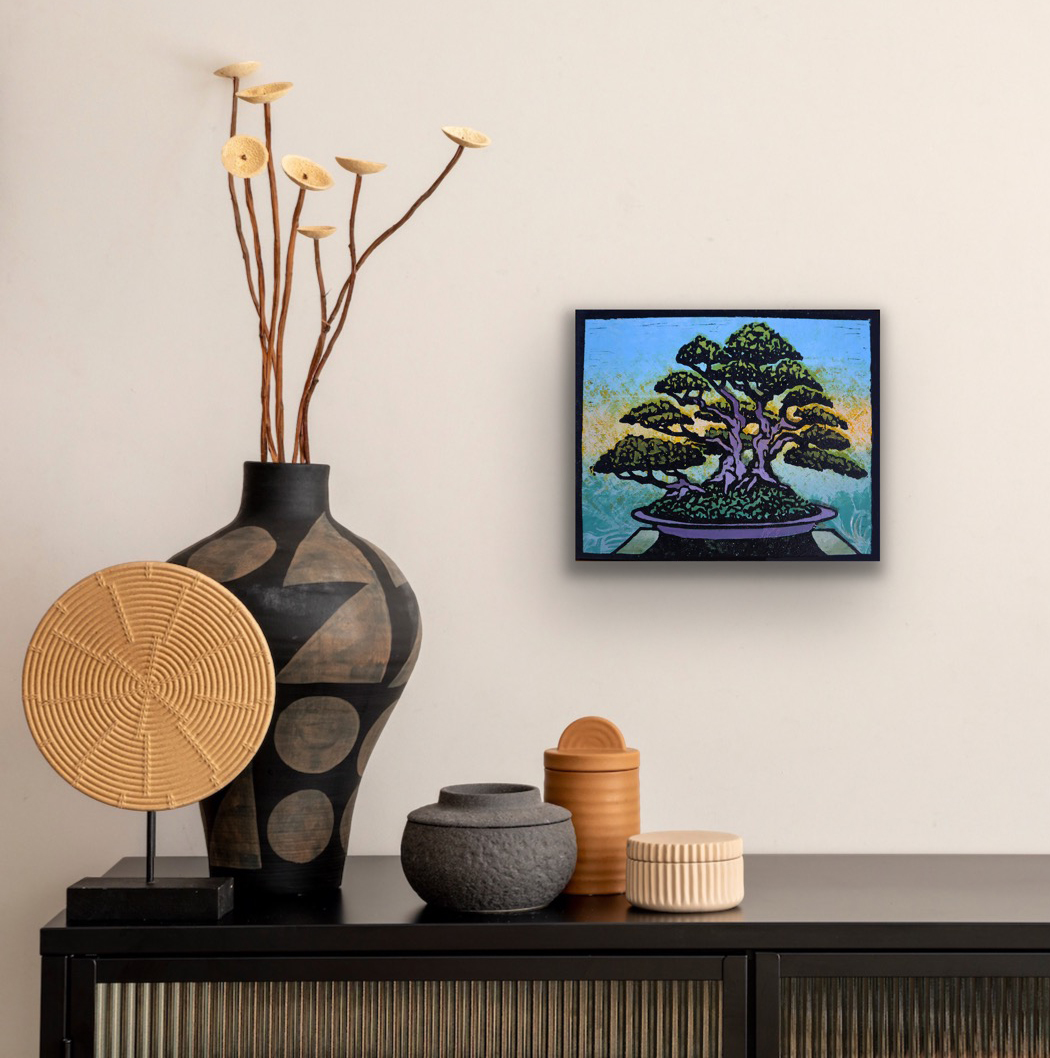 Ota Azalea Monoprint #3 displayed on a neutral interior wall above a dark cabinet with Japanese-inspired ceramic vessels and woven decorative objects.